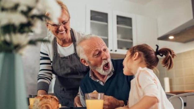 Senior Living Couple Having Dinner Granddaughter