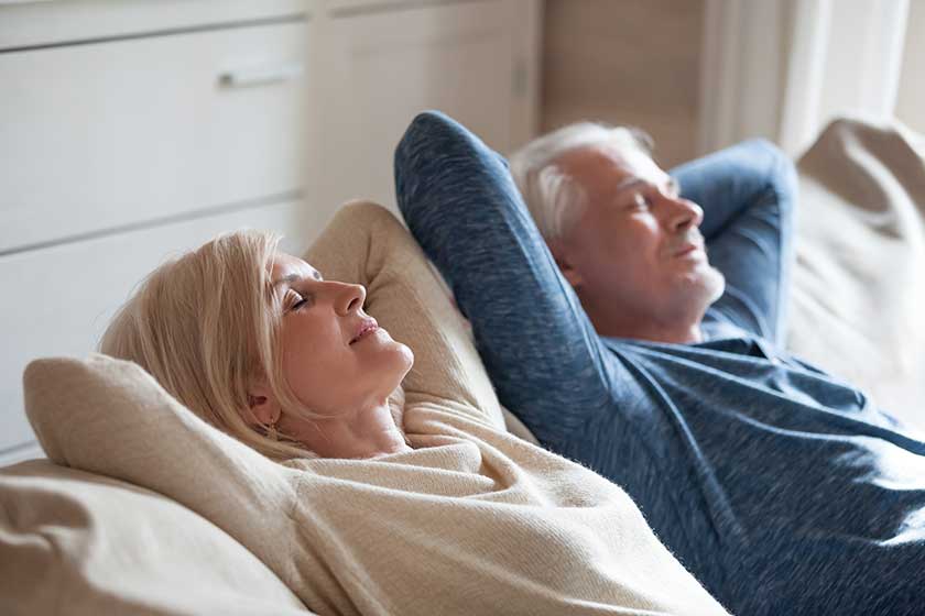 Calm senior mature couple relaxing on soft comfortable sofa having daytime nap together Calm senior mature couple relaxing on soft comfortable sofa having daytime nap together