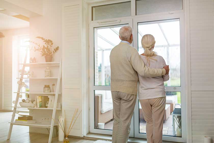 Rearview shot of senior couple looking out living room window