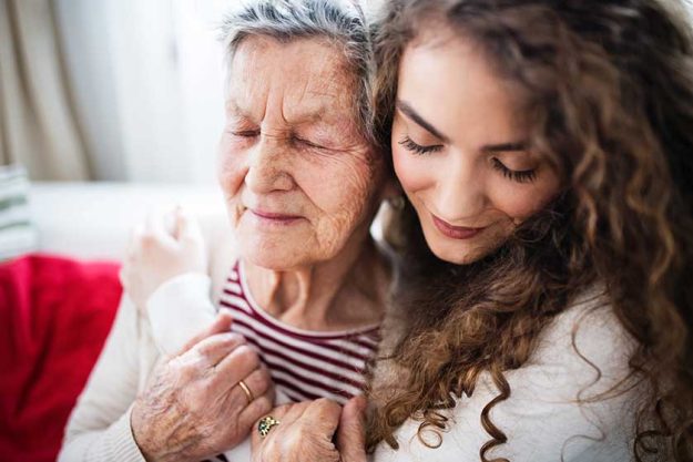 A teenage girl with grandmother at home, hugging A teenage girl with grandmother at home, hugging