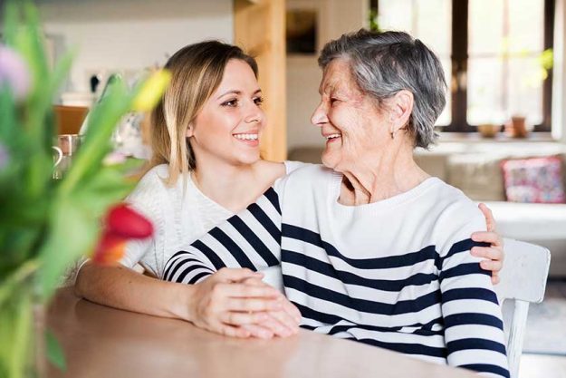 An elderly grandmother with an adult granddaughter at home An elderly grandmother with an adult granddaughter at home