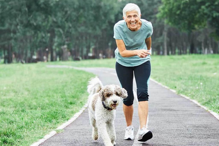 outdoor senior fitness woman lifestyle active sport exercise hea Portrait of a happy active beautiful senior woman with her dog outdoors