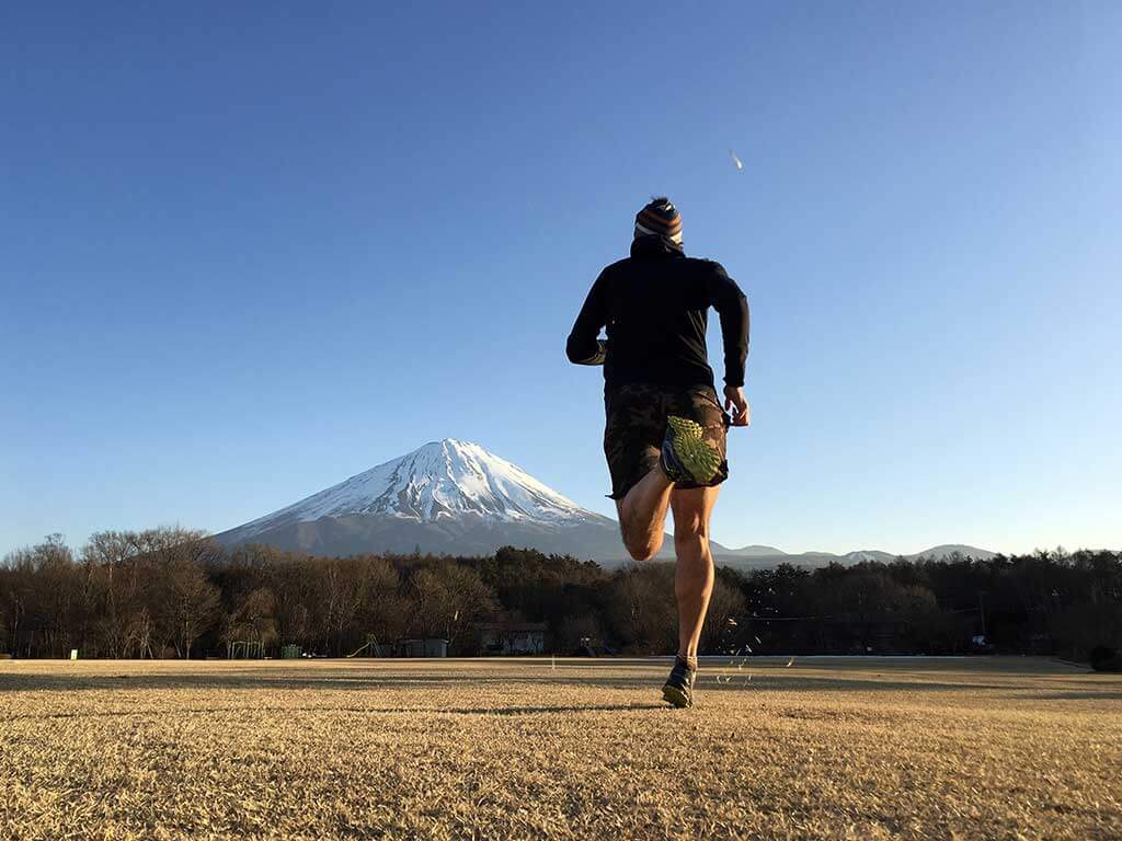 Man running towards snow capped Mt Fuji