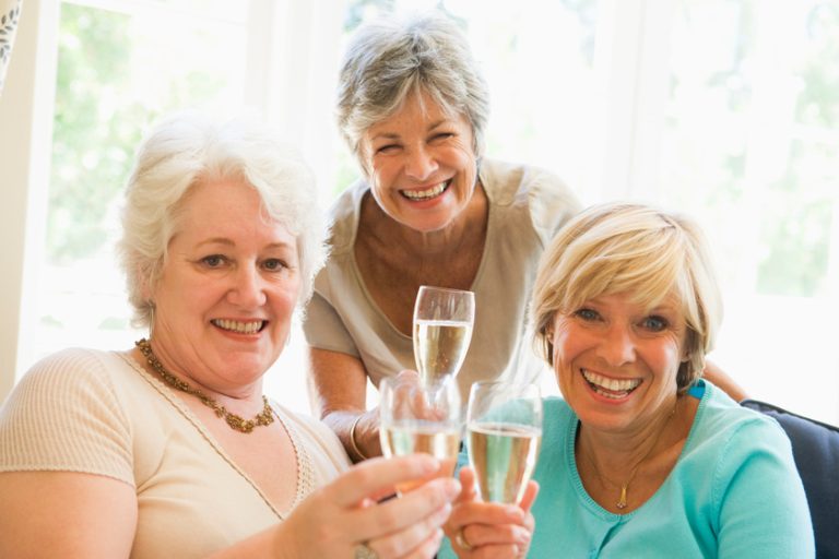 Three women in living room drinking champagne and smiling Alcohol Drinking Guide For Seniors