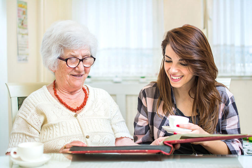 Grandmother and granddaughter looking at photo album together. Grandmother and granddaughter looking at photo album together.