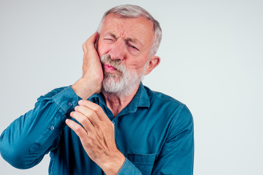 unhappy senior man with closed eyes holding cheek isolated white How Poor Oral Health In Seniors Causes Chronic Diseases