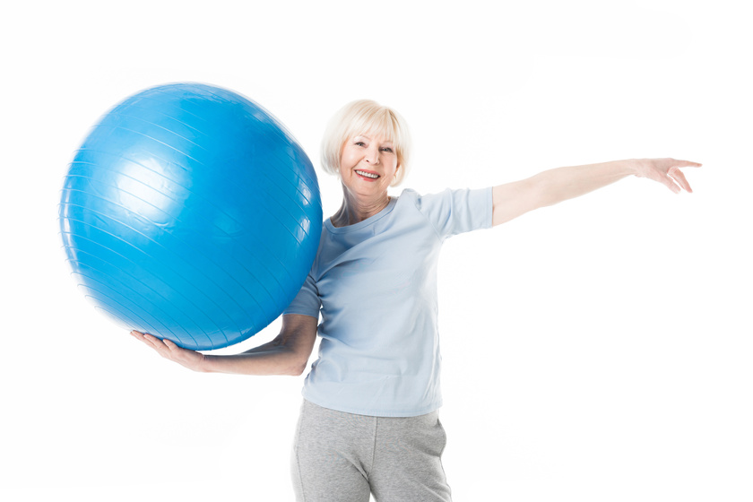 Smiling senior sportswoman holding fitness ball in one hand isol How To Maintain Energy Level As You Age