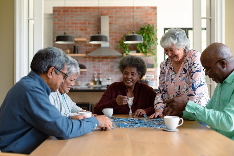 Group of diverse senior male and female friends doing puzzles at 6 Activities To Stimulate Your Loved One With Dementia