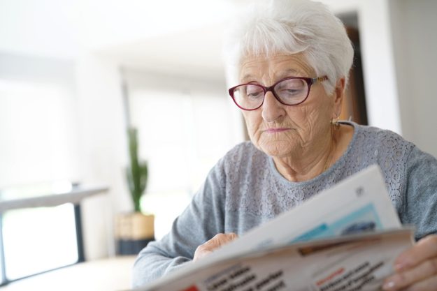 Portrait of old woman reading newspaper at home Portrait of old woman reading newspaper at home