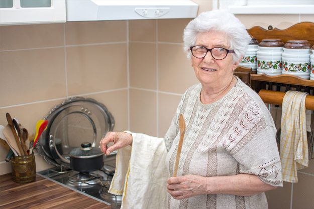 Smiling senior woman cooking in the kitchen.