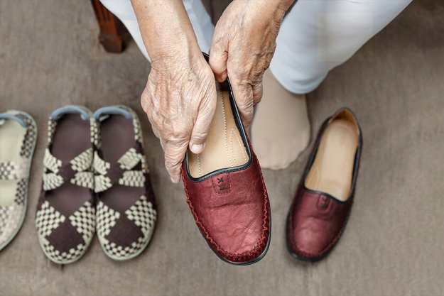 Elderly woman putting on shoes Elderly woman putting on shoes
