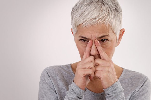 Mature Woman suffering from sinusitis or Allergic rhinitis