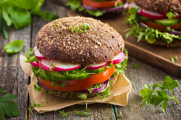 Healthy fast food. Vegan rye burger with fresh vegetables Healthy fast food. Vegan rye burger with fresh vegetables