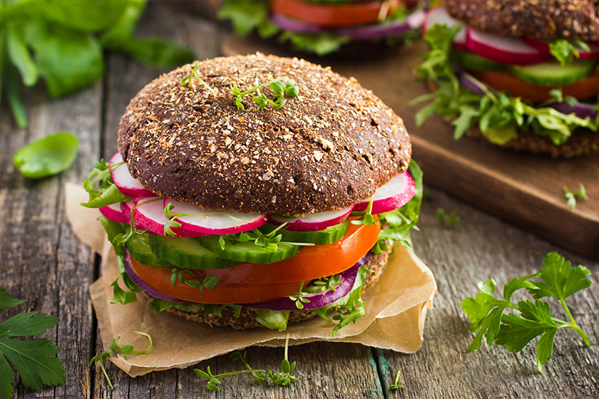 Healthy fast food. Vegan rye burger with fresh vegetables Healthy fast food. Vegan rye burger with fresh vegetables