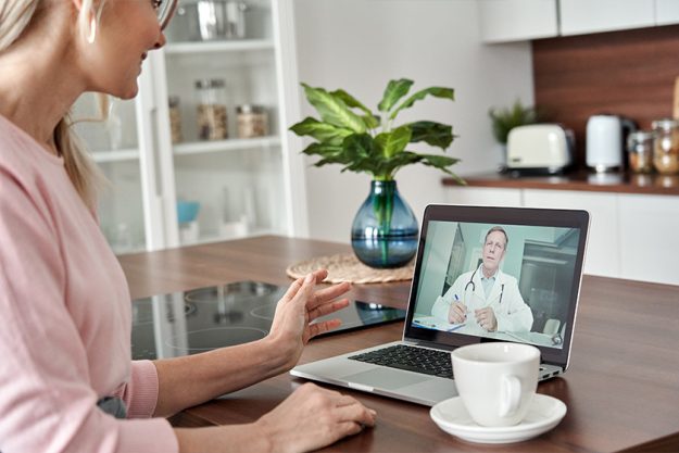 Middle aged female patient getting online telemedicine consultation at home