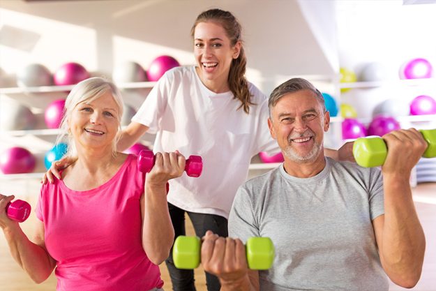 Senior couple training in the gym with a personal trainer Senior couple training in the gym with a personal trainer