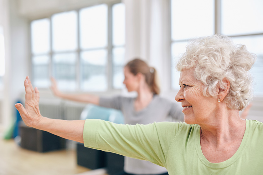Senior woman doing stretching exercise at yoga class Senior woman doing stretching exercise at yoga class