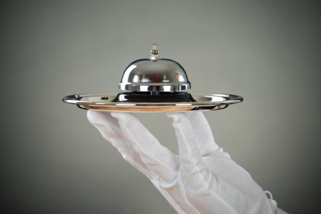 Cropped Hand Of Waiter Holding Service Bell In Tray 8 Concierge Services To Expect In Senior Living Communities In Gary, IN