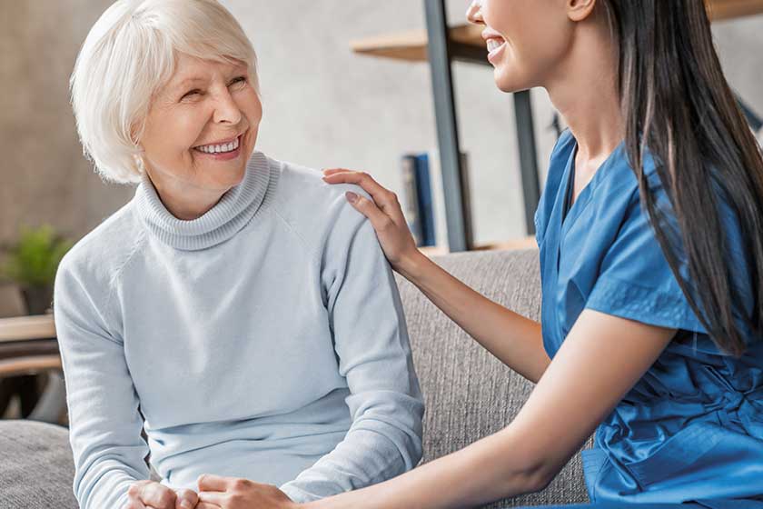 Friendly asian assistant caring senior woman home in living room Friendly asian assistant caring senior woman home in living room