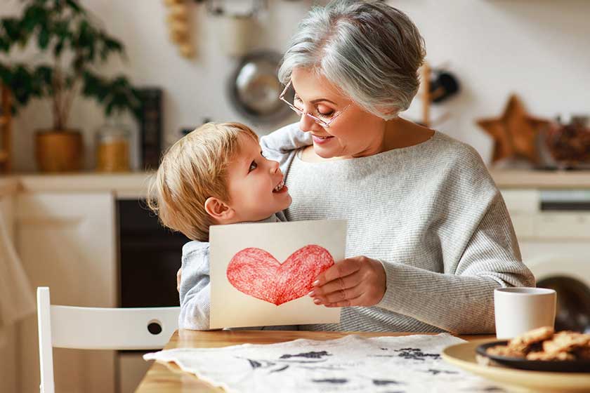 happy family grandson child congratulates grandmother on holiday and gives card. Happy family grandson child congratulates grandmother on holiday and gives card.