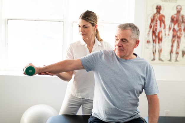 A Modern rehabilitation physiotherapy worker with senior client Here's Why You Need Respite Care After Surgery Or Hospital Stay