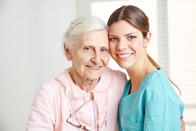 Caregiver embracing happy senior woman How Does Assisted Living Benefit Your Aging Parent?