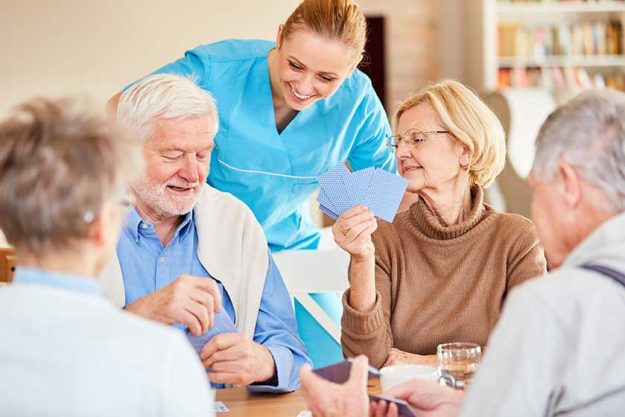 Nursing lady looks on while playing cards Nursing lady looks on while playing cards