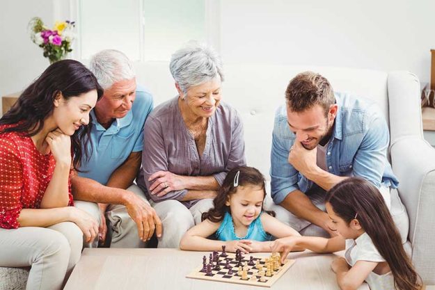 Parents and grandparents looking at girls playing chess Parents and grandparents looking at girls playing chess