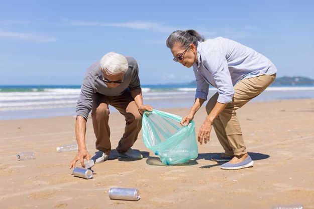 Senior couple collecting rubbish at the beach. environmental protection concept and Good role model. Senior couple collecting rubbish at the beach. environmental protection concept and Good role model.