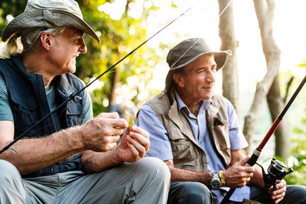Senior friends fishing by the lake