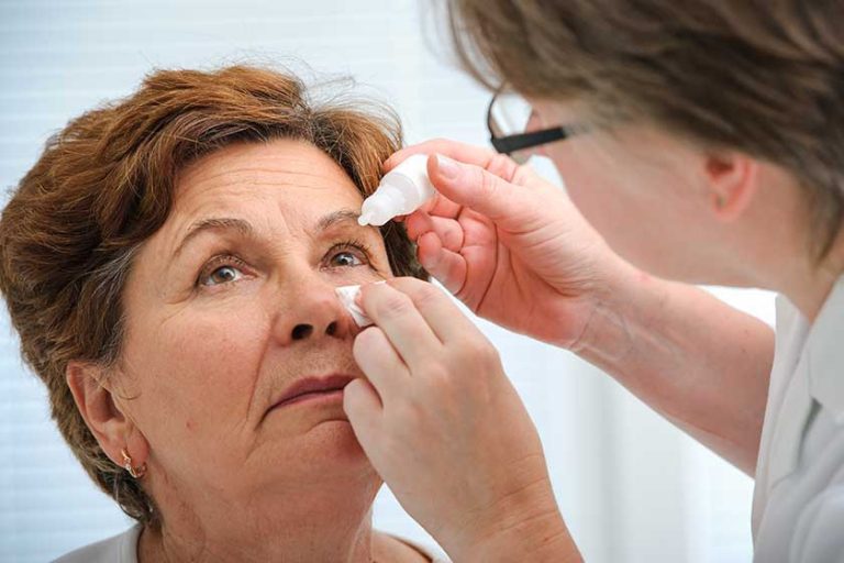 Senior woman applying eye drops Senior woman applying eye drops