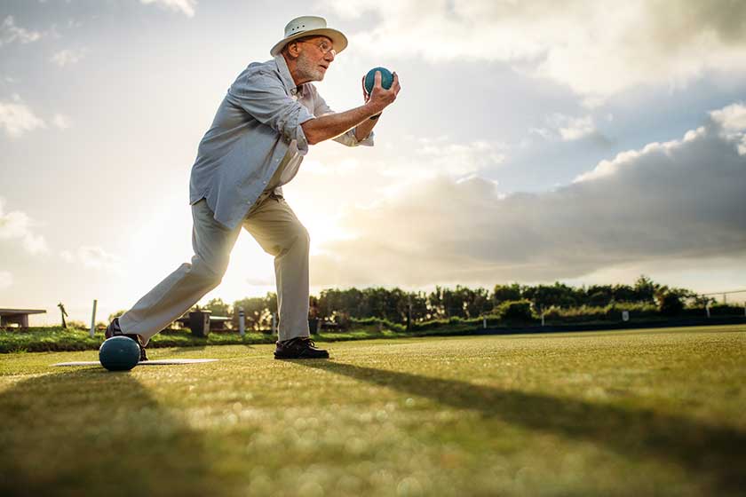 Side view of an elderly man playing boules Side view of an elderly man playing boules