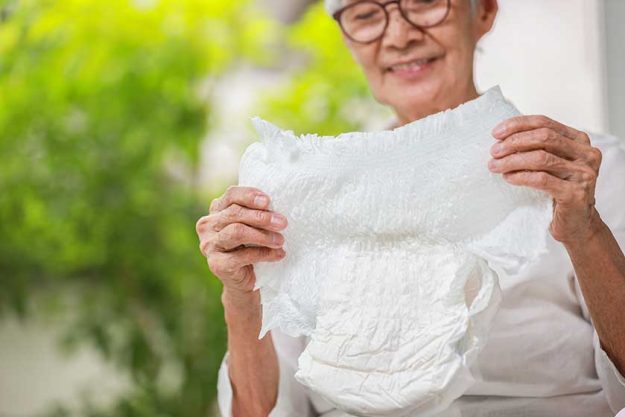 Happy smiling asian senior woman showing disposable diaper for adult Happy smiling asian senior woman showing disposable diaper for adult