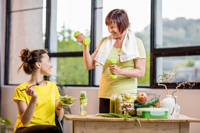 Young and older women exercising with dumbbells Young and older women exercising with dumbbells