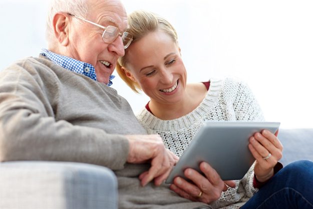 Happy father and daughter using digital tablet at home Happy father and daughter using digital tablet at home