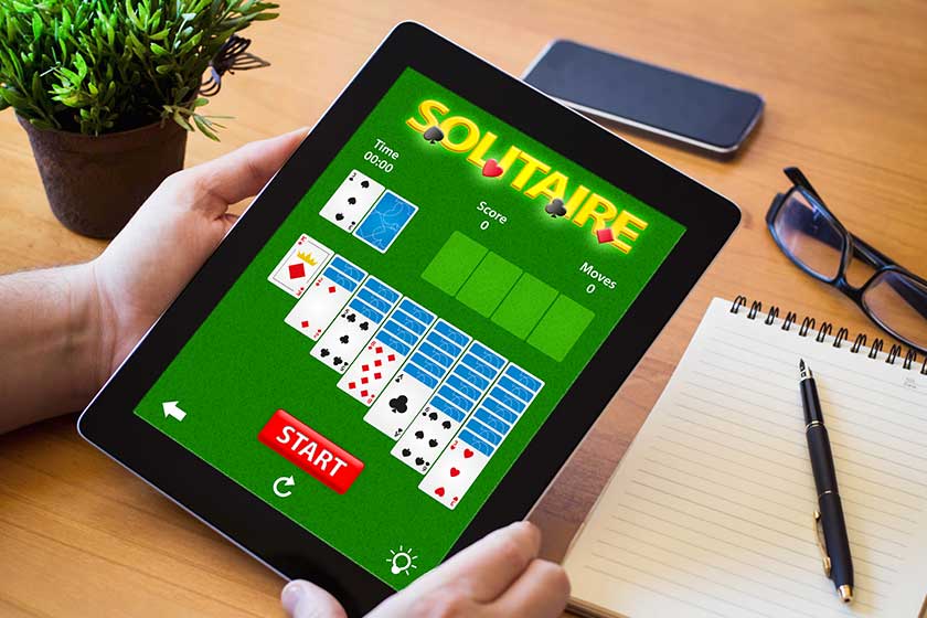 Man playing solitaire app on tablet