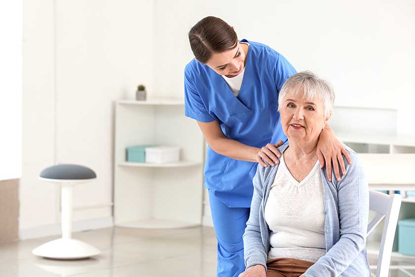 Female doctor with senior woman suffering from Parkins