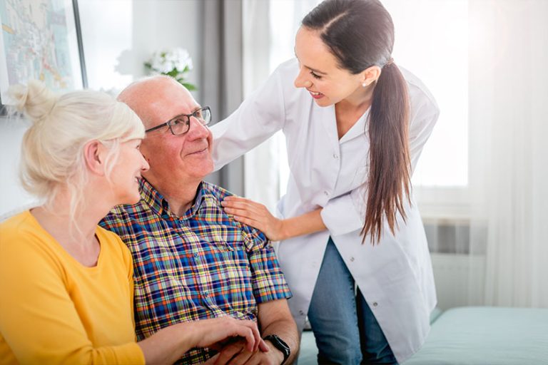 Smiling nurse talking with senior couple