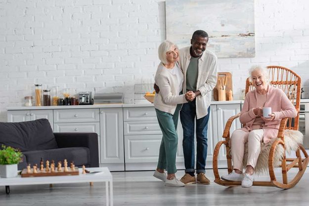Happy interracial pensioners dancing near friend Happy interracial pensioners dancing near friend