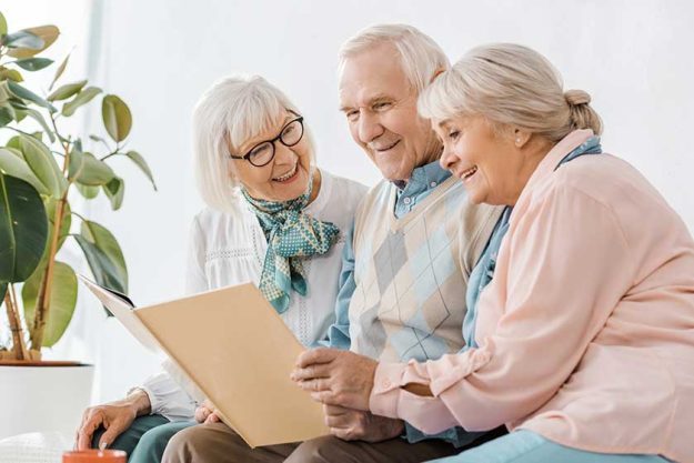 Senior smiling people reading book together Senior smiling people reading book together