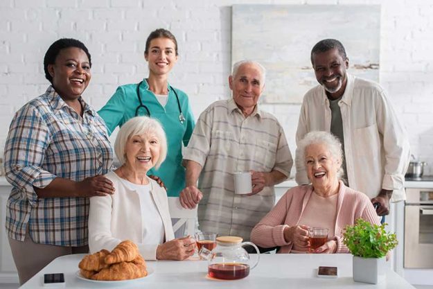 Smiling nurse standing near interracial patients