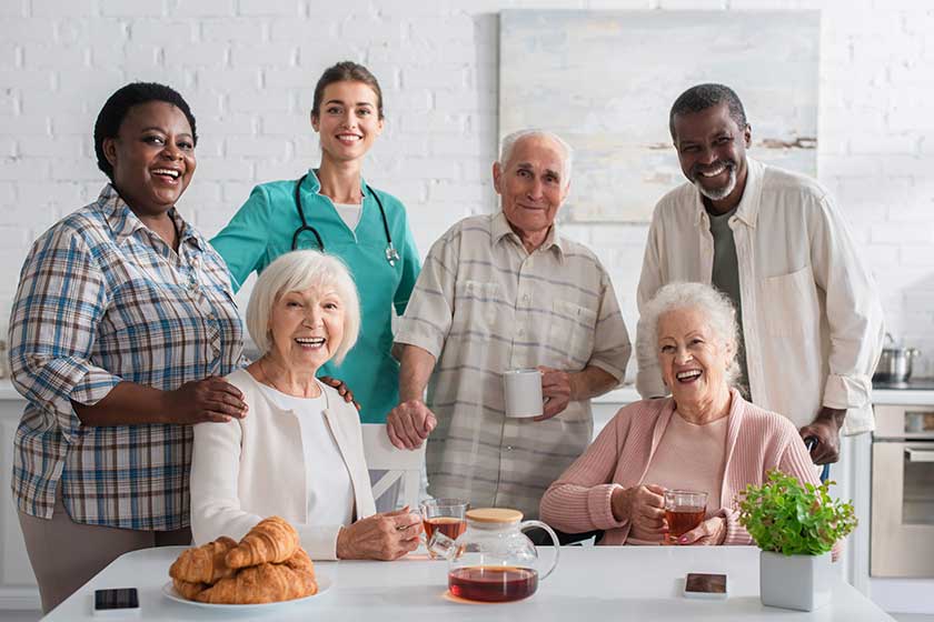 Smiling nurse standing near interracial patients Smiling nurse standing near interracial patients