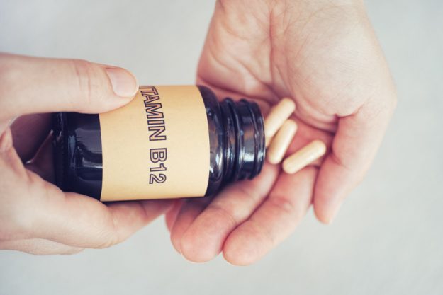 Person taking out Vitamin B12 pills out of bottle X Ways Senior Assisted Living In Washington, PA Protects You From Vit B12 Deficiency