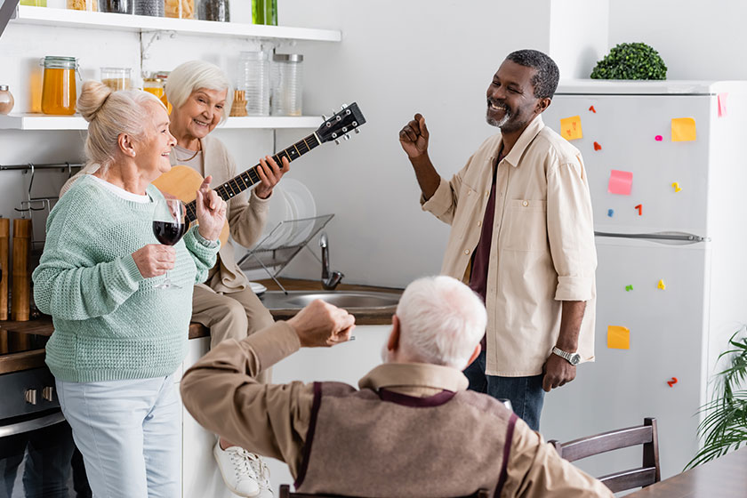 Happy Retired Woman Playing Acoustic Guitar Cheerful Multicultural Friends Kitchen Happy Retired Woman Playing Acoustic Guitar Cheerful Multicultural Friends Kitchen