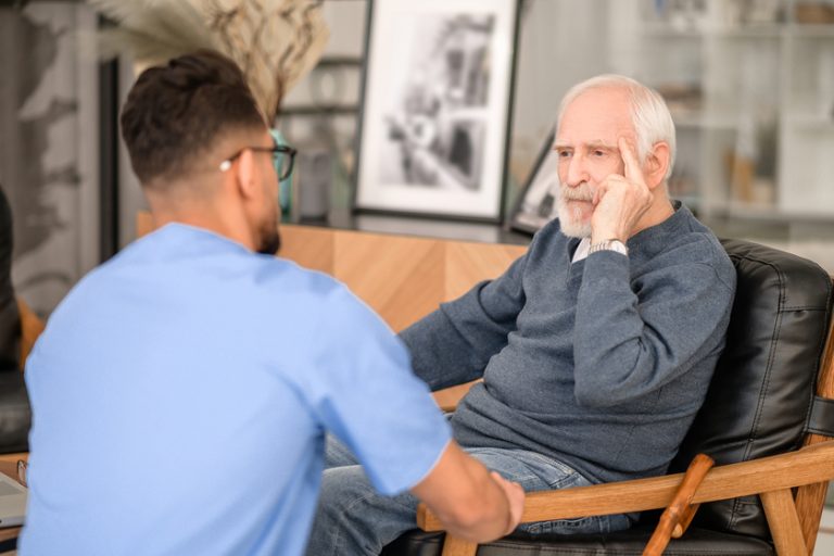 Despondent pensioner seated in the room before his caretaker How Memory Care Communities In Dorneyville, PA, Can Keep Seniors Safe From Wandering