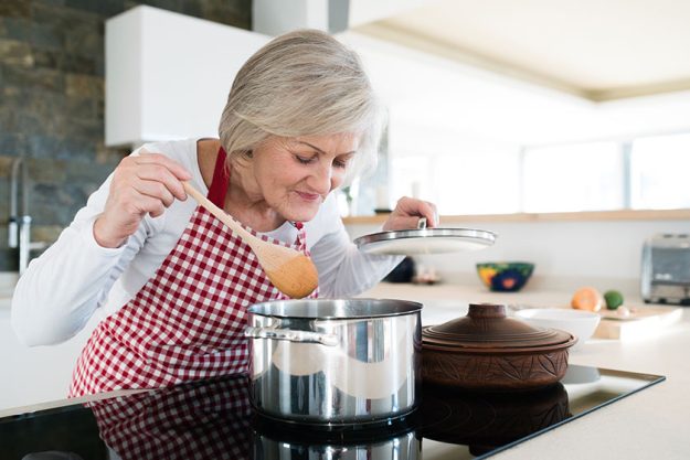 Senior woman in the kitchen cooking
