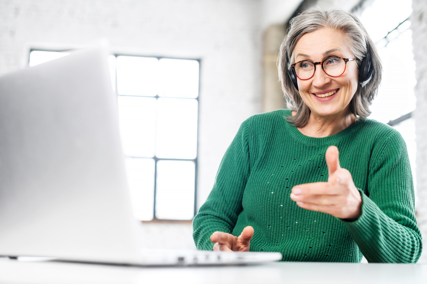 Beautiful senior woman wearing headset using laptop Beautiful senior woman