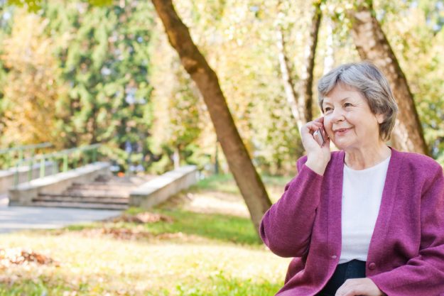 elderly women with phone in autumn park How Memory Care Facilities in Fishers, IN Maintain Residents' Mental Health