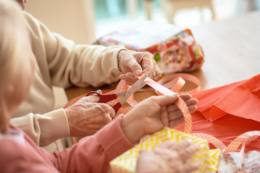Close up picture of hands packing christmas gifts