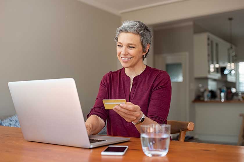 Happy senior woman making online payments of bill